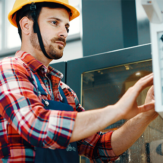 Male CNC operator works at controls