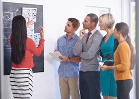 Woman in marketing explains cartoons to a group of people