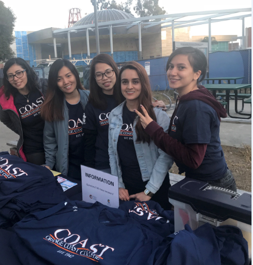 Group of students at information table with t-shirts