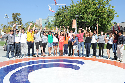 Group of students standing together by OCC Logo