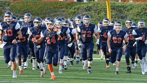 OCC football team together running on football field